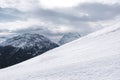 Snowy mountain slope. Winter landscape in the Alps. High mountains in the background