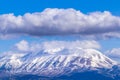 A snowy mountain under dense clouds. Blue sky Royalty Free Stock Photo