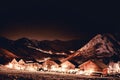 Snowy mountain with village into the dark with stars