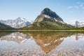 A snowy mountain water reflection on Swiftcurrent Lake in Many Glacier region of Glacier National Park, Montana. Grinnell Point, a Royalty Free Stock Photo