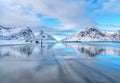 Snowy mountains and blue sky with clouds reflected in water Royalty Free Stock Photo