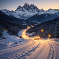 Snowy mountains and blurred car headlights on the winding road at night in winter. Beautiful landscape with snow Royalty Free Stock Photo