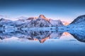 Snowy mountains and colorful sky reflected in water at sunset Royalty Free Stock Photo