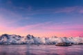 Snowy mountains and colorful sky reflected in water at sunset Royalty Free Stock Photo