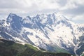 Snowy mountains range. Rocky mountain peaks in cloudy sky. View on Caucasus highlands. Royalty Free Stock Photo