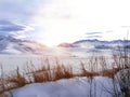 Snowy mountains and ridge  brown grass in the foreground. Winter landscape Royalty Free Stock Photo