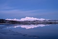 Snowy mountains, sea bay, reflection in water at sunset in winter Royalty Free Stock Photo