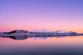 Snowy mountains, sea bay, reflection in water at sunset in winter Royalty Free Stock Photo