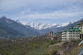 Snowy mountains white color house with green roof