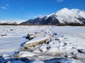 Snowy mudflats with visible ice churn, Turnagain Arm, outside of Girdwood, Alaska on a clear winter day.