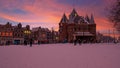 Snowy Nieuwmarkt with the Waag building in the city center from Amsterdam in the Netherlands at sunset Royalty Free Stock Photo