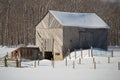 Snowy old barn with diagonal boards and barnyard landscape Royalty Free Stock Photo