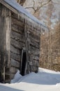 Snowy old log cabin barn with icicles Royalty Free Stock Photo