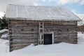 Snowy old log cabin barn with icicles Royalty Free Stock Photo