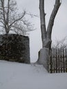 Snowy passage between an old castle wall and a wooden fence Royalty Free Stock Photo