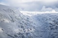 Snowy path with shoeprints, path in snow with clouds on the background, footsteps and path in snow