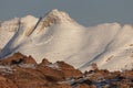 Snowy peak of the South Guardian Angel, Utah with red sandstone ridge in front