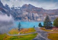 Snowy peaks in the morning mist. Foggy autumn scene of unique Oeschinensee Lake. Royalty Free Stock Photo