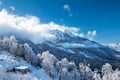 Snowy peaks of mountains above the clouds and gondola lift on a clear winter day Royalty Free Stock Photo