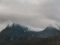 Snowy peaks of the mountains covered with the dark clouds of the sky Royalty Free Stock Photo