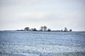 Snowy plowed field in a rural countryside in nature during chilly and cold weather. Winter landscape on a farm with Royalty Free Stock Photo