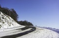 A snowy road curve in the mountains with a large graduated blue Royalty Free Stock Photo