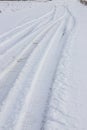 Snowy road in a field leading to pine forest. Winter road to nowhere in sunny day, snow-covered fresh car track. Car Royalty Free Stock Photo