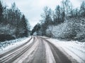 Snowy road surrounded by pine trees Royalty Free Stock Photo