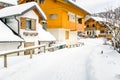 Snowy Road through Traditional Alpine Wooden Houses Royalty Free Stock Photo
