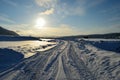 Snowy road with tromsoe city island in the background at sunrise Royalty Free Stock Photo