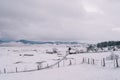 Snowy road in a village on the edge of a forest in a mountain valley Royalty Free Stock Photo