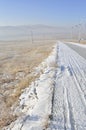 Snowy road with wind turbines and Street lamps powered by solar panels and wind turbine Royalty Free Stock Photo