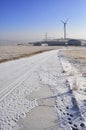 Snowy road with wind turbines and Street lamps powered by solar panels and wind turbine Royalty Free Stock Photo