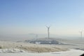 Snowy road with wind turbines and Street lamps powered by solar panels and wind turbine Royalty Free Stock Photo