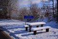 A snowy roadside rest area in Germany with tables and benches in winter, which is deserted