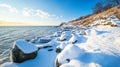 Snowy Rocks and Calm Water on a Coastline Under a Blue Sky Royalty Free Stock Photo