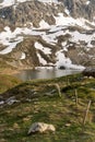 Snowy rocks and the lake at the top of the Julier mountain pass Royalty Free Stock Photo