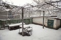 Snowy rural courtyard with homemade table, chairs and bench