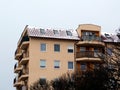 Snowy rustic brown clay roof on mid-rise condo on winter day