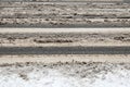 Snowy, slippery and muddy pedestrian crossing. Spreading salt on the road