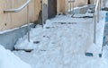 Snowy slippery stairs of the porch in winter day.