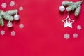 Snowy sprigs of pine, snowflakes, decorative star and chrismas balls isolated on red background. Christmas and new year. Royalty Free Stock Photo