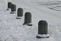 Snowy squares and streets with mosaic cobblestone tiles made of granite and white marble separated by stone bollards stone pillars