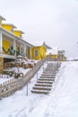 Snowy stairs along wooden fence of homes in Utah