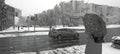 Snowy street view person with umbrella and road cityscape march weather black and white background