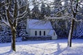 Chapel in snowy forest landscape with snowman at path Royalty Free Stock Photo