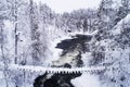 A snowy suspension bridge over river rapids during a cold winter day