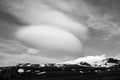 Snowy volcanic mountain and interesting shaped clouds in a sunny day in black and white