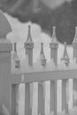 Black and white depiction of a small section of decorative fence in the snow.