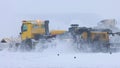 Snowy winter at the airport - a big snowplow removes snow from the path Royalty Free Stock Photo